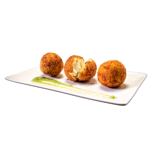Tres croquetas gourmet de textura crujiente y dorada, servidas sobre una elegante bandeja blanca con una delicada guarnición verde. Una de las croquetas aparece abierta, mostrando su cremoso y sabroso relleno en el interior. Presentación gastronómica cuidada, ideal para representar tapas, aperitivos y cocina gourmet.